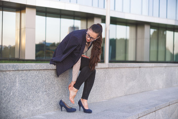 Woman massaging heel suffering from walking on high heels.