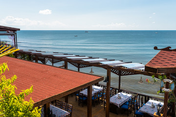 Restaurant in Nessebar on the coast of the beautiful Black Sea in Bulgaria, visible sea line and boats.