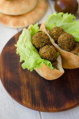 Falafel balls with lettuce salad and pita.