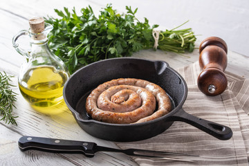 cooked coiled sausage on cast iron pan