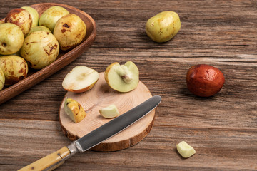 ripe and unripe jujube fruit on cutting board on wooden table