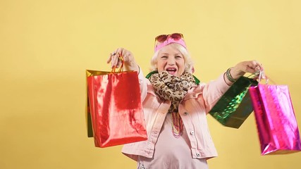 Gorgeous pretty old woman expresses positive emotion, does the shopping at weekend. Holiday concept.