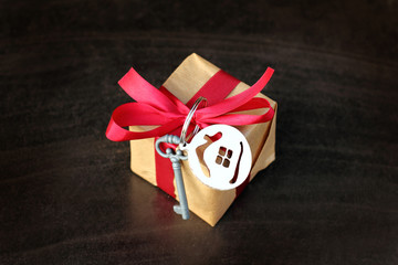 gift idea with key symbol and house in the shape of a ball for tree decoration on a dark background. real estate in Christmas style
