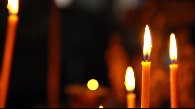 Large burning candles close-up in the Orthodox Church, smooth focus from one subject to another