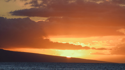 Sunset over a slope and ocean.