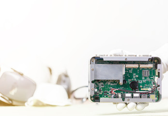 Hand holding tiny electronic circuit board inserting to the socket, abstract technology background, engineering and technical experimental kit concept.