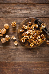 Walnuts. Kernels and whole nuts on wooden rustic table, top view