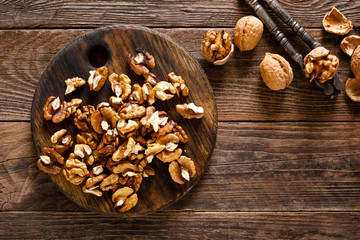 Obraz na płótnie Canvas Walnuts. Kernels and whole nuts on wooden rustic table, top view