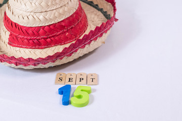 Mexican hat and september 15 made from wooden letters and colorful numbers on white background. 