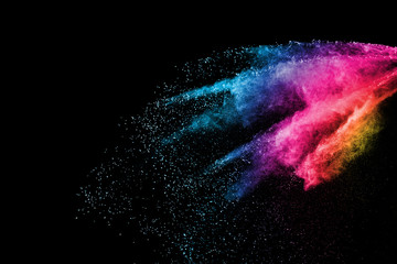 Freeze motion of purple color powder exploding on black background.