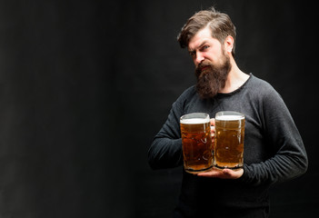 Oktoberfest. Beer time. Beer pub. Smiling bearded man with craft beer from mug. Alcohol, harmful habits. Stylish handsome man drinking beer of glass on party. Stylish guy at cafe pub. Copy space.