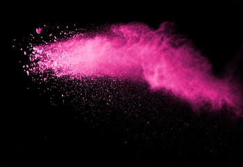 Pink powder explosion on black background. Paint Holi.