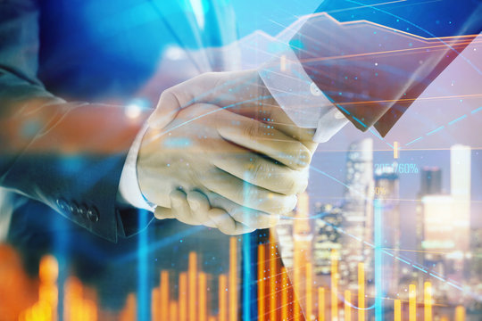 Double exposure of financial chart on cityscape background with two businessmen handshake. Concept of financial analysis and investment opportunities
