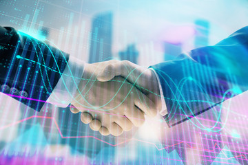 Double exposure of financial graph on cityscape background with two businessman handshake. Concept of stock market deal