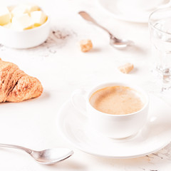 Traditional breakfast with fresh croissants on white background.