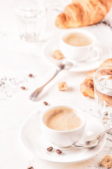Traditional breakfast with fresh croissants on white background.