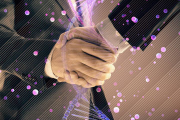 Multi exposure of DNA hologram on abstract background with two men handshake. Concept of...