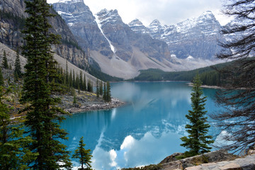 Fototapeta na wymiar Rocky Mountains Surrounding Beautiful Green - Blue Coloured Lake