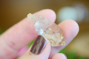 Clear quartz point on wood table in natural lighting. Woman's hand - High Quality Clear Quartz healing stone, One of a Kind Quartz Point, great for a reiki healing! Unique formations, Quartz Scepter.