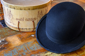 A historic hatbox from Berlin in the 19th century with a bowler on an old wooden table. seit is German for since. © Mickis Fotowelt