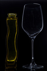 Bote de colonia y copa de vino sobre fondo negro
