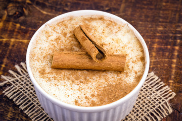 Creamy rice pudding sprinkled with cinnamon, typical Brazilian dessert.