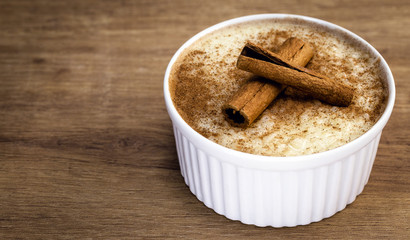 Sweet decorated with cinnamon. Brazilian tasty dessert on wood background.