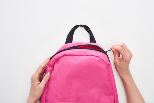 Partial View Of Schoolgirl Zipping Bright Pink Schoolbag Isolated On White