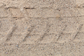 Embossed Wheel Tracks Into Sandy Rural Dirt Road