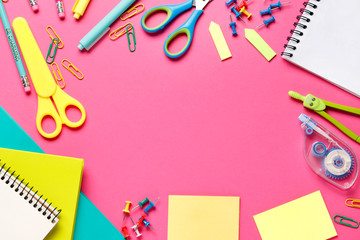 Colorful composition of school supplies: crayons, scissors, markers, globe, rulers, paints. Copy space in the center. Vibrant color background. Flat lay. Back to school.