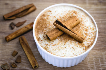 Creamy rice pudding sprinkled with cinnamon, typical Brazilian dessert.