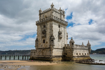 Fototapeta na wymiar Old tower over a cloudy sky in Lisbon, Portugal