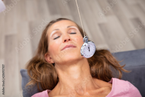 Woman Being Hypnotized While Lying On Sofa