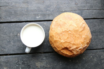 Bread with milk lies on the old vintage table.
