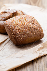Gold rustic crusty loaves of bread and buns on wooden background. Still life captured from above top view, flat lay.