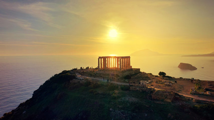 Aerial drone photo of sunset over the iconic Temple of Poseidon at Cape Sounio with amazing golden colours, Attica, Greece