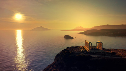 Aerial drone photo of sunset over the iconic Temple of Poseidon at Cape Sounio with amazing golden colours, Attica, Greece - obrazy, fototapety, plakaty