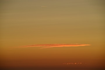 Summer sunset, Jersey, U.K. Backgrounds image of orange colours with cloud.