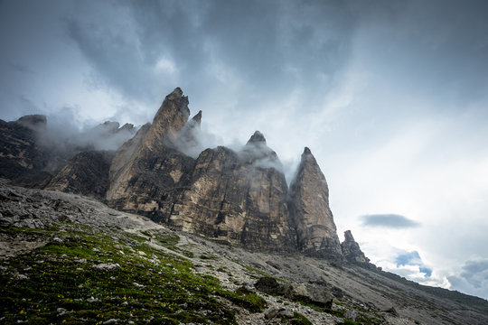 au pied de trois tours rocheuses sous d'&eacute;pais nuages 