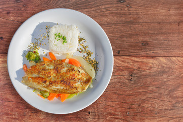 Tilapia with rice and vegetables as a side.