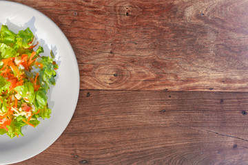 Tasty fresh salad over a wooden background