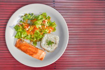 Tasty Salmon with rice and salad as a side