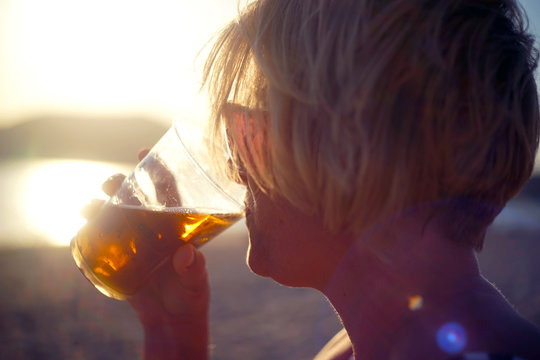silhueta de mulher bebendo na praia 