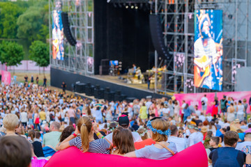 Women are watching concert at open air music festival