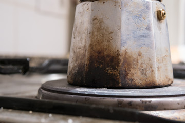 burnt and old coffee maker on electric cooker