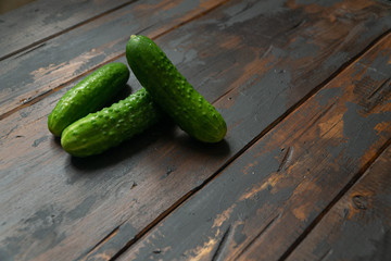 Bunch of fresh green cucumbers on a old wooden table. Organic food.