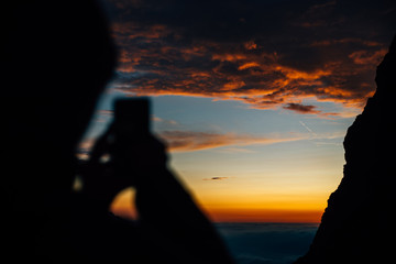 silhouette of person taking a photo with a smartphone