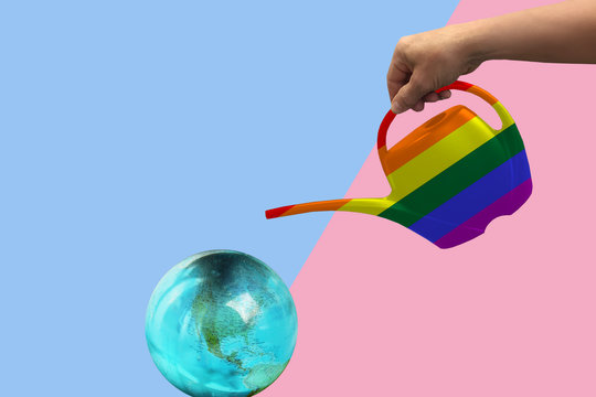rainbow symbol of the gay parade on the watering can, which waters the earth globe model, a symbol of giving life on the planet, on a geometric background in bright pink, blue, copy space