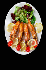 Shrimp, salad, lemon on a plate