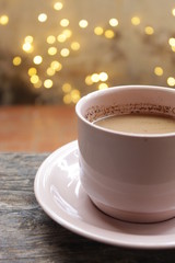 brown cup of coffee on wooden table with blurred bokeh background